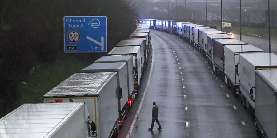 Lastwagen stehen in langen Schlangen auf der M20 in der Nähe von Folkestone in der Grafschaft Kent im Stau, nachdem der Zugang zum Eurotunnel nach der Ankündigung der französischen Regierung, in den nächsten 48 Stunden keine Passagiere aus Grossbritannien zu akzeptieren, geschlossen wurde. Foto: Steve Parsons/PA Wire/dpa