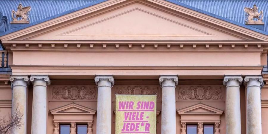 Ein Transparent mit der Aufschrift "Wir sind viele - Jeder einzelne von uns" am geschlossenen Mecklenburgischen Staatstheater in Schwerin. Foto: Jens Büttner/dpa-Zentralbild/dpa