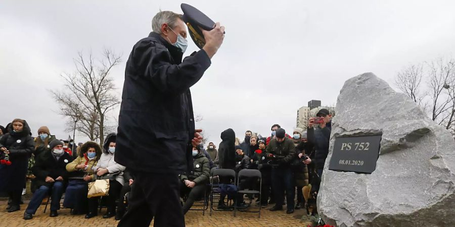 Ein Pilot legt Blumen vor der Gedenkstätte für die Opfer des Absturzes einer ukrainischen Passagiermaschine nieder. Ein Jahr nach dem Abschuss des Flugzeuges dringt Präsident Selenskyj auf den Beginn eines Gerichtsverfahrens. Foto: Efrem Lukatsky/AP/dpa