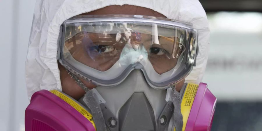 dpatopbilder - Ein Rettungssanitäter in Schutzkleidung bereitet sich darauf vor, einen COVID-19-Patienten abzuholen. Foto: Marco Ugarte/AP/dpa