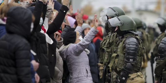 Demonstranten in Belarus stellen sich mit erhobenen Händen vor die Polizei. Belarus Minsk protest