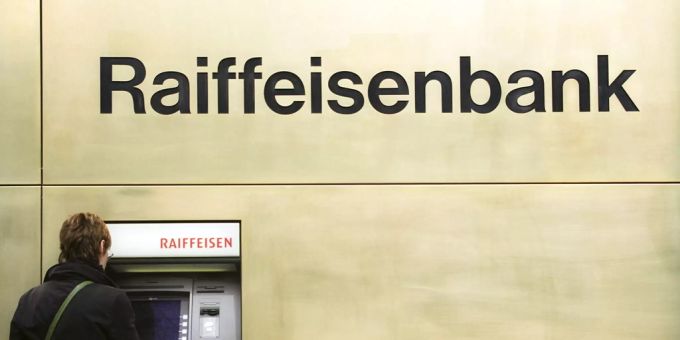 Eine Frau steht an einem Geldautomaten der Raiffeisenbank.