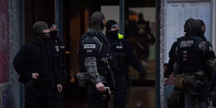 Polizisten und SEK-Beamte stehen vor einem Haus an der Stresemannstrasse in Kreuzberg. Am frühen Morgen des zweiten Weihnachtstages fielen hier Schüsse. Vier Männer wurden schwer verletzt. Foto: Paul Zinken/dpa