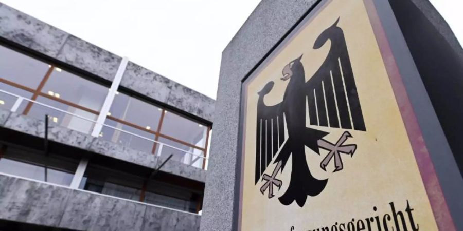 Das Bundesverfassungsgericht mit einem Hinweisschild mit Bundesadler und dem Schriftzug Bundesverfassungsgericht. Foto: Uli Deck/dpa