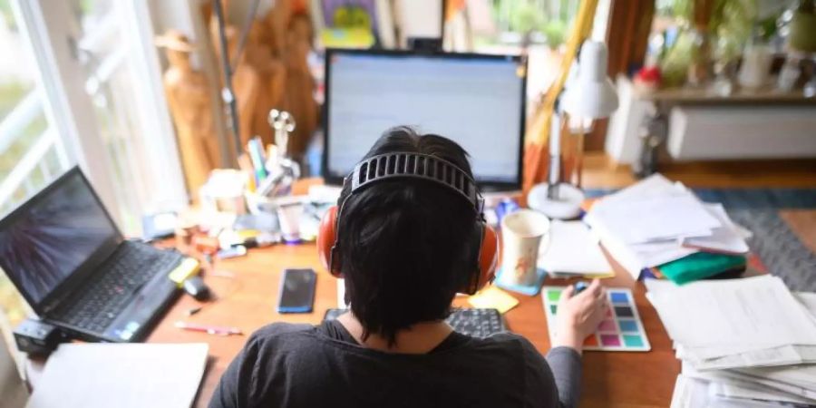 Eine Frau arbeitet mit Hörschutz im Homeoffice. Wer während der Corona-Krise von zu Hause arbeitet, soll seine Ausgaben leichter in der Steuererklärung geltend machen können. Foto: Sebastian Gollnow/dpa