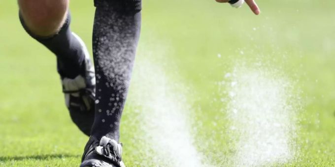 Ein Bundesliga-Schiedsrichter sprüht Freistossspray auf den Rasen. Foto: Friso Gentsch/dpa Ein Bundesliga-Schiedsrichter sprüht Freistossspray auf den Rasen. Foto: Friso Gentsch/dpa