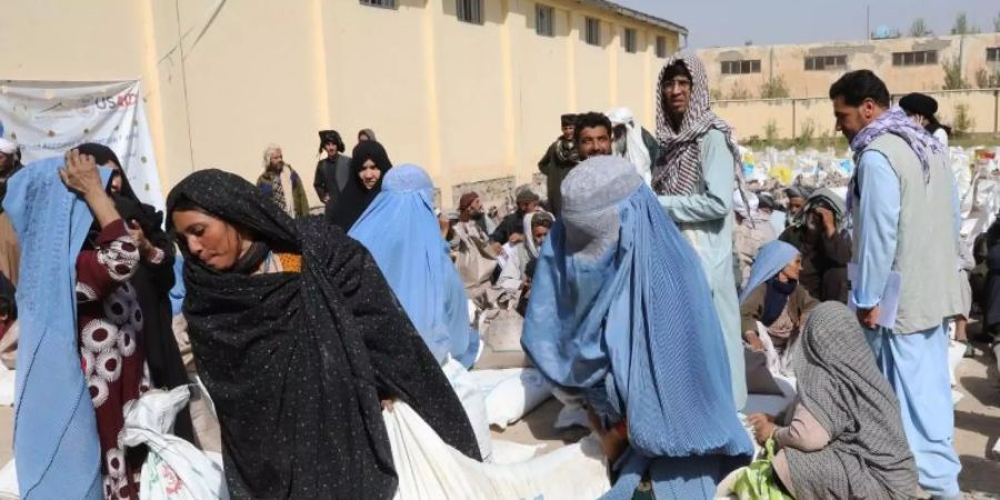 Frauen verlassen eine Verteilungsstelle des Welternährungsprogramm WFP am Stadtrand von Herat mit Lebensmittelrationen. Foto: Marco Di Lauro/WFP/dpa