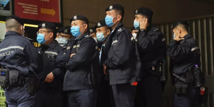 Polizisten bewachen den Eingang zum Büro von «Stand News». Hongkong