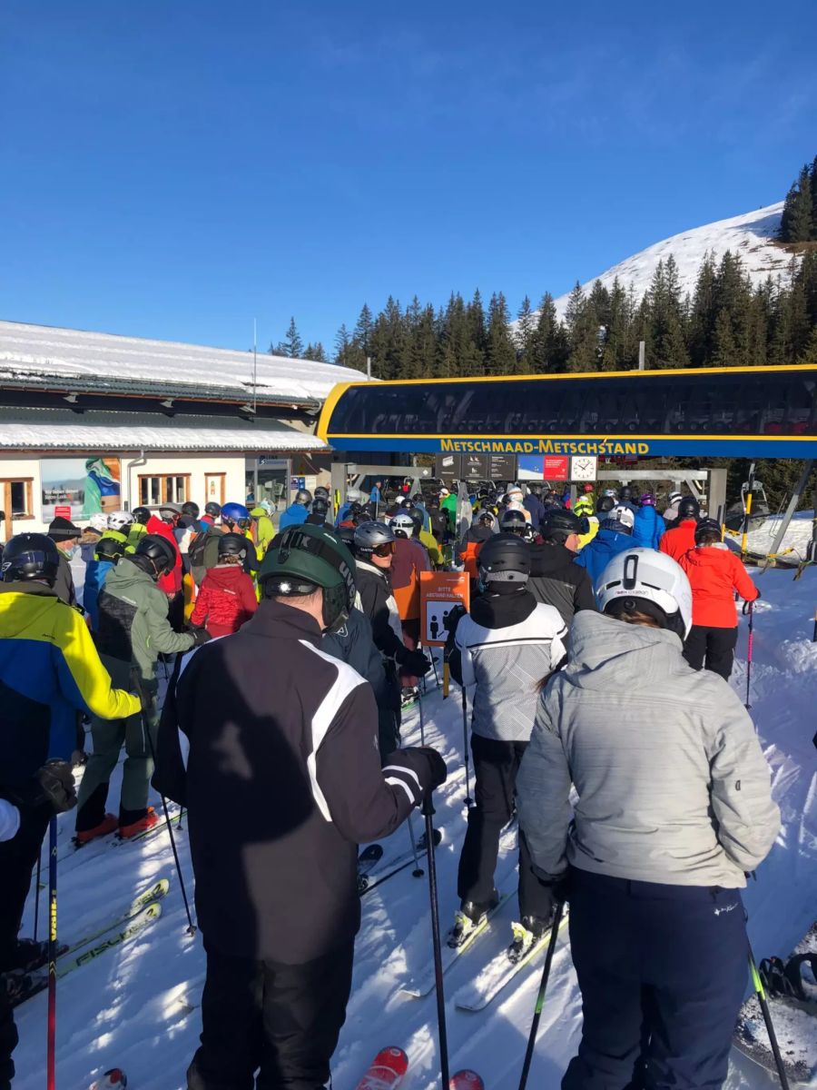 Menschen warten an Silvester im Skigebiet Adelboden-Lenk auf den Lift.