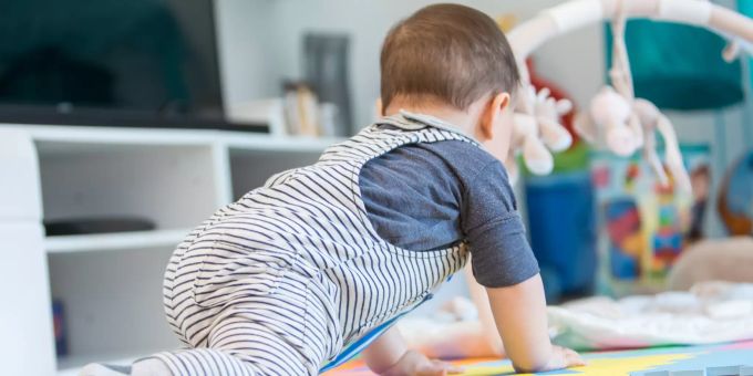 Die meisten Babys und Kleinkinder haben laut Experten O-Beine. Durch das Laufen werden sie (erstmal) gerade. Baby krabbelt.