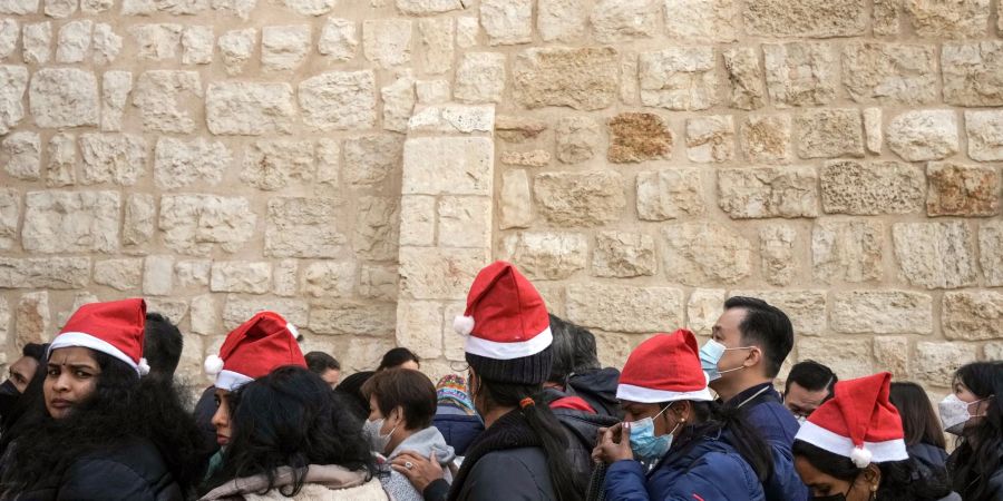 Heiligabend im vergangenen Jahr: Touristen - einige mit Weihnachtsmützen - stehen in Bethlehem vor der Geburtskirche Schlange.