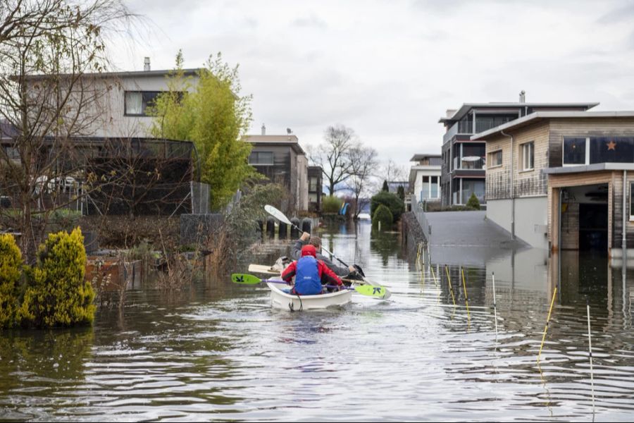 Quartierbewohner paddeln während des Hochwassers mit ihrem Boot zu ihrer Wohnung im Quartier Ried in Giswil am Sarnersee im Kanton Obwalden, am Mittwoch, 13. Dezember 2023 in Giswil im Kanton Obwalden.