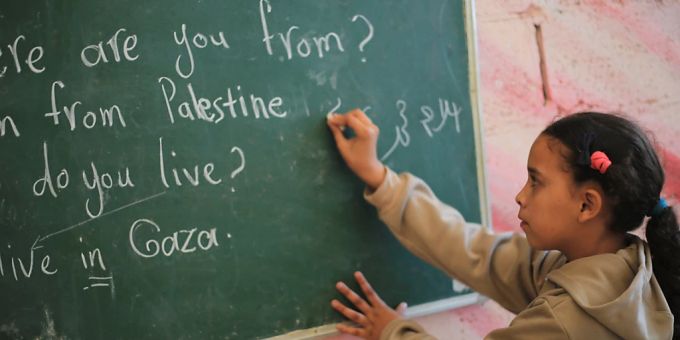 Ein palästinensisches Mädchen schreibt an eine Tafel. Wegen des Gaza-Krieges mangelt es im Gazastreifen an Bildungsmitteln. Foto: Mohammed Talatene/dpa Schüler im Gazastreifen