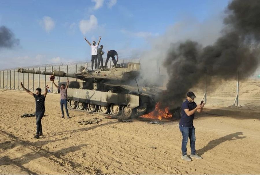 Dieses Bild zeigt feiernde Hamas-Kämpfer auf einem israelischen Panzer.