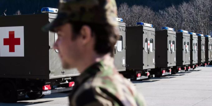 Will, aber kann nicht: Ein Angehöriger der Schweizer Armee vor Sanitätsfahrzeugen. armee Coronavirus