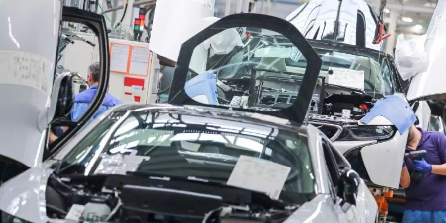 Mitarbeiter im BMW-Werk Leipzig bei der Montage des i8 Sportwagens. Foto: Jan Woitas/dpa-Zentralbild/dpa