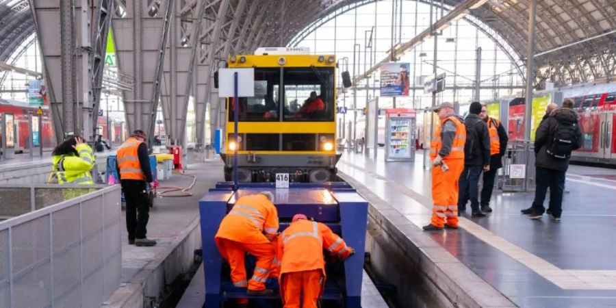 Mitarbeiter der Deutschen Bahn reparieren beschädigten Prellbock