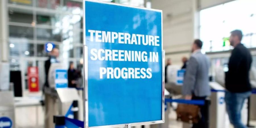 Sicherheitsmassnahme auf der Reifenmesse in Hannover. Ein Schild weist am Eingang auf eine Einrichtung zur Messung der Körpertemperatur hin. Foto: Hauke-Christian Dittrich/dpa