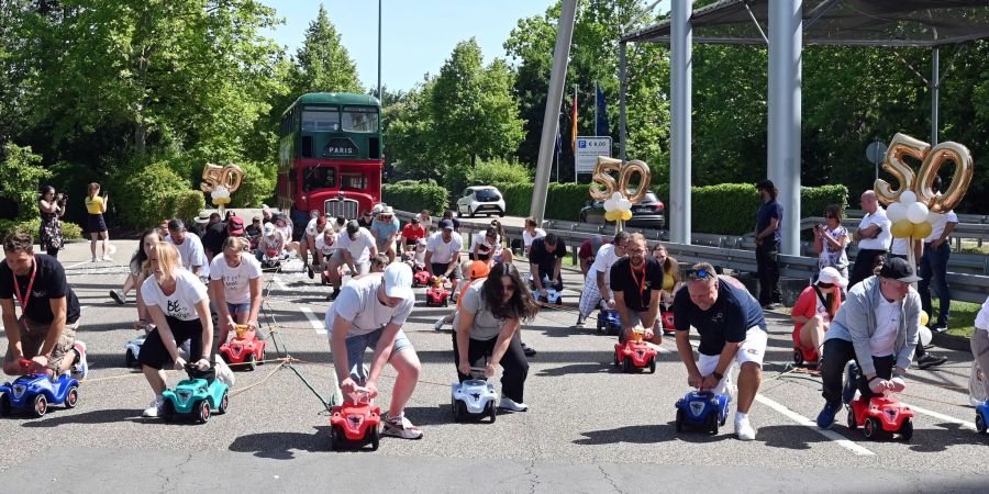 Im Europa-Park ziehen 50 Menschen auf Bobby-Cars den Bus der Kelly Family 50 Meter weit.