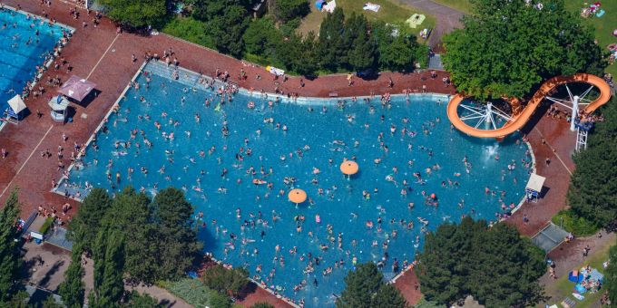 Menschen baden und sonnen sich im Sommerbad am Insulaner im Berliner Bezirk Steglitz. (Luftaufnahme). massenschlägerei