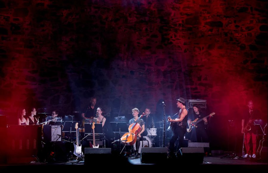 Orchester Licht rot Cello Steinwand Burg