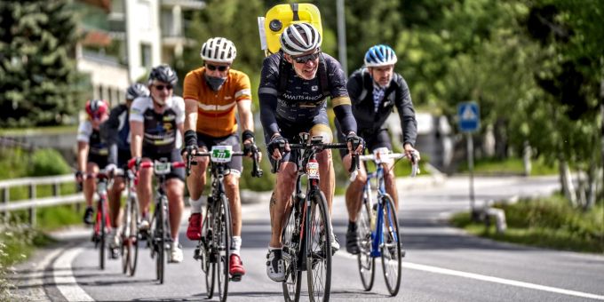Die WasserträgerInnen machen mit einem gelben Kanister auf dem Rücken auf die Spendenaktion aufmerksam. Gruppe von Radfahrern