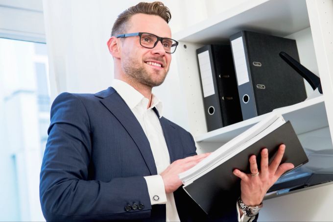 Kreativität lässt sich in der Regel nicht erzwingen – es braucht Geduld und die Musse, auch mal nichts zu tun. Mann an Bücherregal