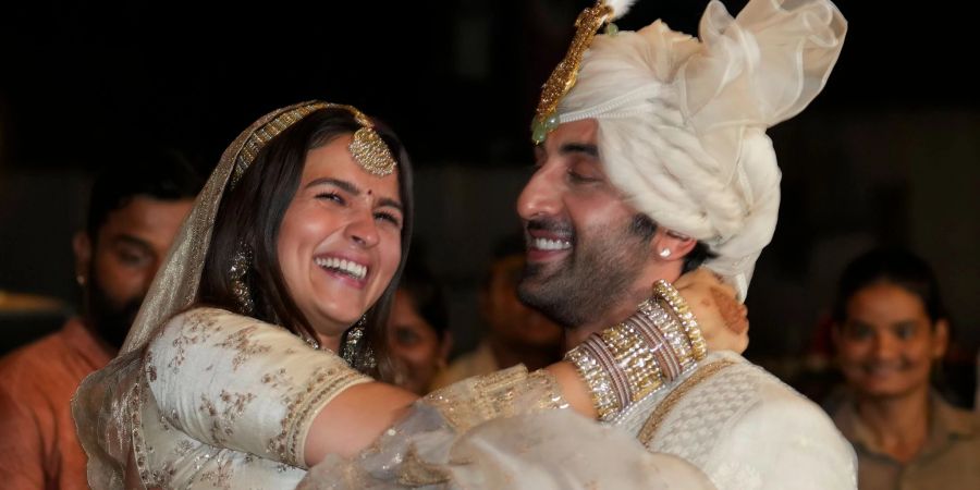 Die Bollywood-Schauspieler Ranbir Kapoor (r) und Alia Bhatt nach ihrer Hochzeit vor ihrem Haus in Mumbai.