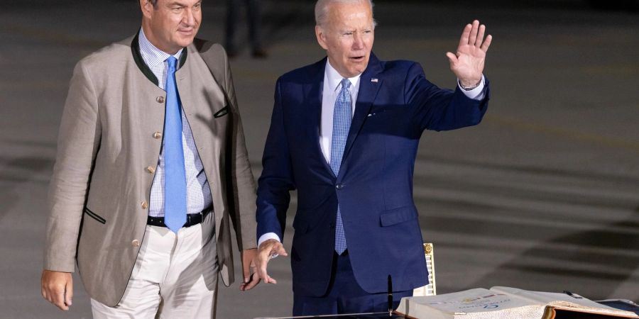 US-Präsident Joe Biden winkt nach seiner Ankunft am Flughafen München neben Markus Söder (CSU), Ministerpräsident von Bayern.