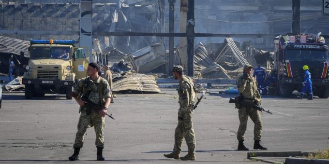 Ukrainische Soldaten stehen vor einem Einkaufszentrum in Krementschuk, das von Raketen getroffen wurde. Ukraine-Krieg