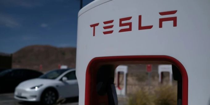 Ein Tesla an einer Ladestation. dow jones industrial average