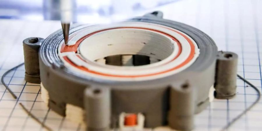 Ein 3D-Drucker bringt eine isolierende Schicht Keramik auf einen Elektromotor auf: Immer mehr kleine und mittlere Unternehmen in Deutschland investieren laut einer Studie in die Digitalisierung. Foto: Jan Woitas/Symbolbild