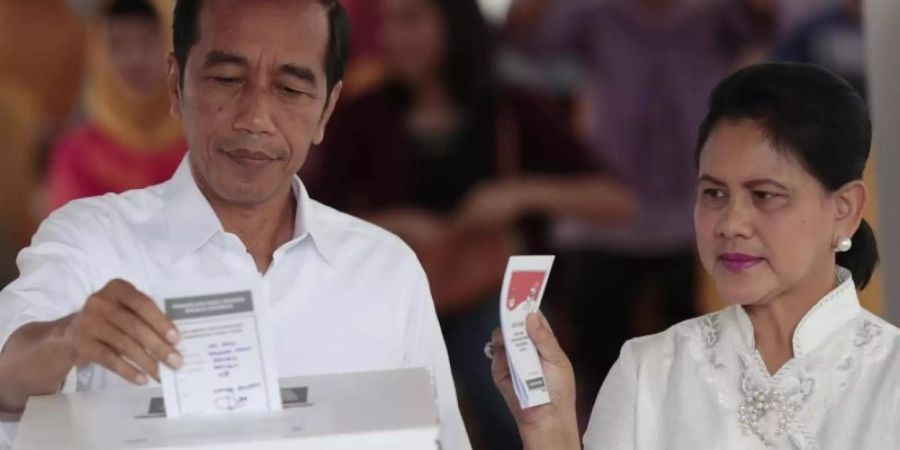 Joko Widodo, Präsident von Indonesien, und seine Frau Iriana geben in einem Wahllokal in Jakarta ihre Stimme ab. Foto: Dita Alangkara/AP