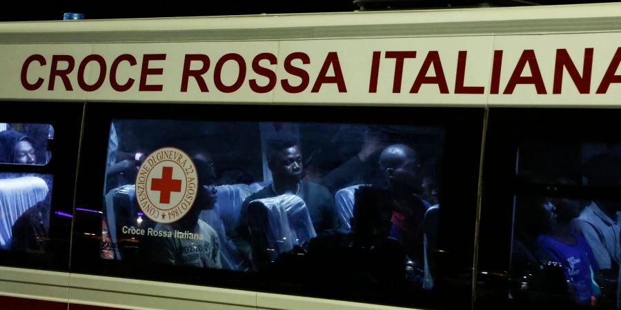 Gerettete Menschen sitzen in einem Bus, nachdem sie auf Lampedusa von einem Boot gestiegen sind.