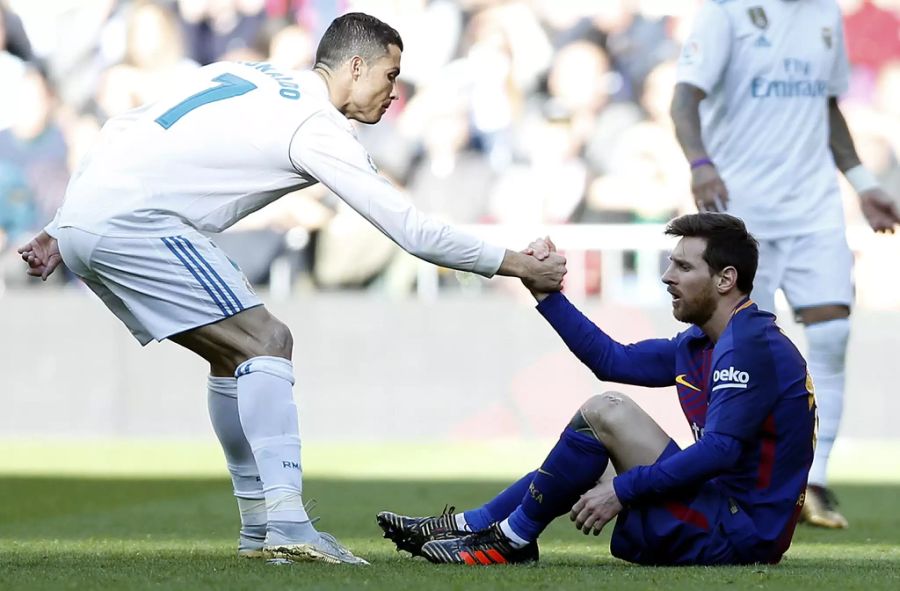 Cristiano Ronaldo (l., damals noch bei Real Madrid) hilft Lionel Messi auf die Beine. (Archivbild)