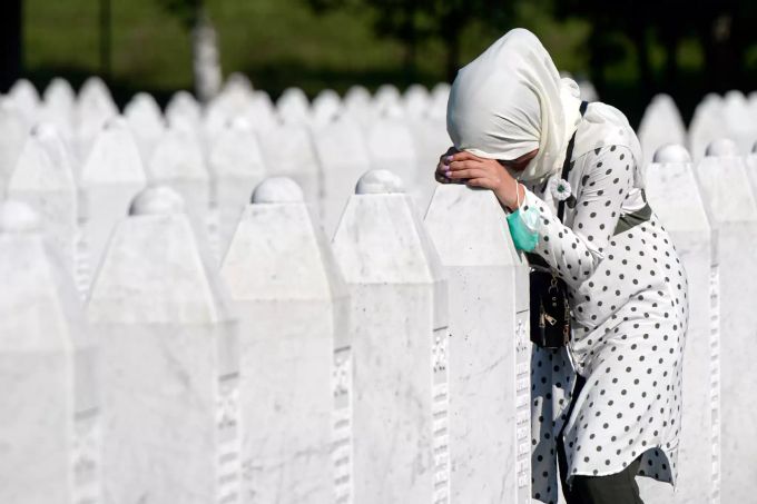 Eine Frau trauert auf dem Friedhof der Gedenkstätte Potocari in der Nähe von Srebrenica an einem Grab. Srebrenica Völkermord