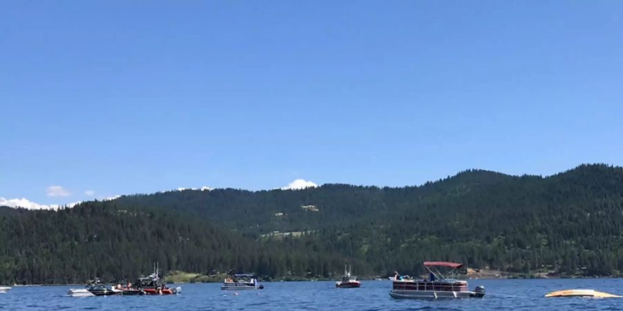 HANDOUT - Boote sind in der Buch von Powderhorn am See Coeur d'Alene Nahe der Absturzstelle eines Wasserflugzeugs (r). Mindestens zwei Menschen sind beim Zusammenstoss zweier Kleinflugzeuge über einem See im US-Bundesstaat Idaho ums Leben gekommen. Foto: Stephanie Hammett/The Spokesman-Review/AP/dpa - ACHTUNG: Nur zur redaktionellen Verwendung und nur mit vollständiger Nennung des vorstehenden Credits