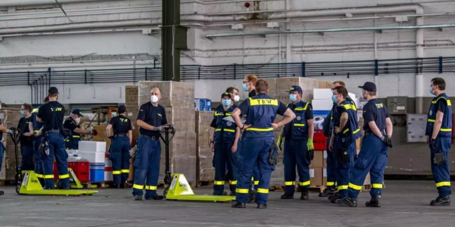 Mitarbeiter des Technischen Hilfswerks richten ein Corona-Testzentrum auf dem Gelände des ehemaligen Militärflughafens in Gütersloh ein. Foto: David Inderlied/dpa