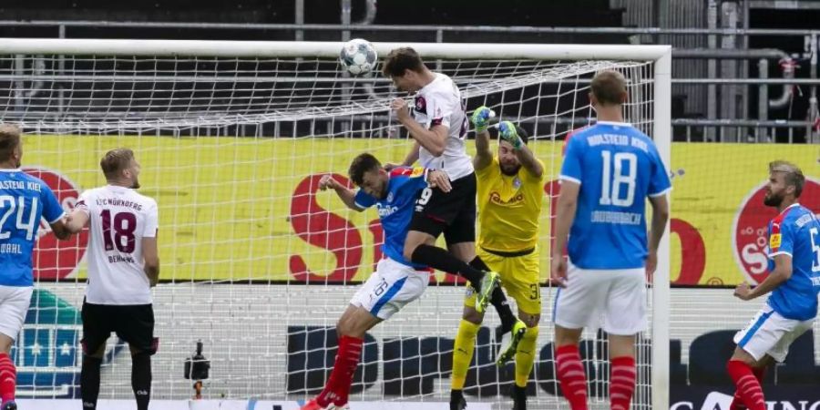 Patrick Erras (4.v.l.) springt höher als Kiels Jonas Meffert nickt zum 1:0 für die Nürnberger ein. Foto: Frank Molter/dpa