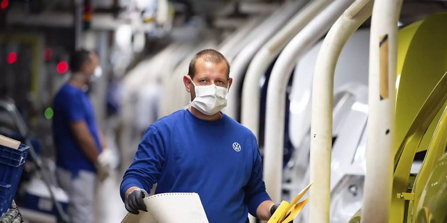 Bei Volkswagen lief es auch schon besser: ein Arbeiterin Wolfsburg mit Maske.