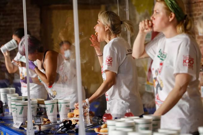 Miki Sudo (2.v.r) isst während eines Wettbewerbs im Hotdog-Wettessen neben ihren Mitstreiterinnen einen Hotdog. In der Frauenriege stellte Titelverteidigerin Miki Sudo mit 48,5 Hotdogs in zehn Minuten ebenfalls einen neuen Rekord auf. Es war ihr siebter Sieg in dem Wettbewerb. hotdogs