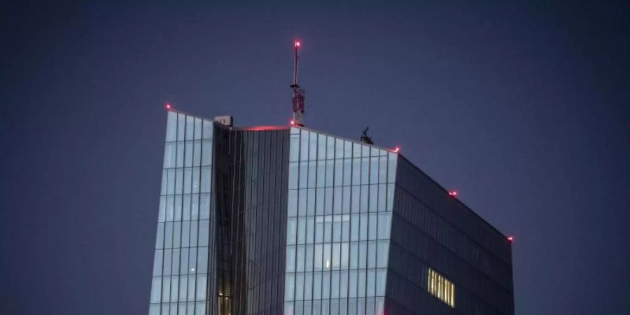 Nur wenige Lichter leuchten am späten Abend in den oberen Etagen der Europäischen Zentralbank in Frankfurt am Main. Foto: Boris Roessler/dpa
