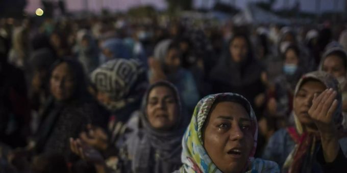 Migranten beten auf der Strasse in der Nähe der Stadt Mytilini auf der Insel Lesbos. Nach dem Grossbrand im Flüchtlingslager Moria auf Lesbos bleibt die Lage auch nach Öffnung erster Ersatz-Unterkünfte angespannt. Lesbos Moria Flüchtlinge