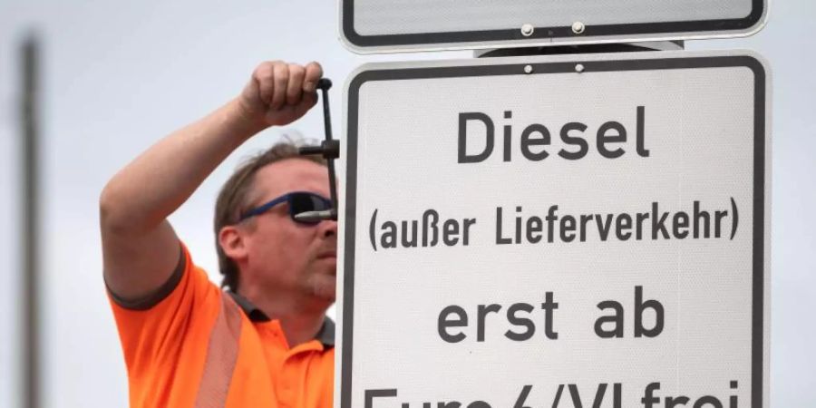 Ein Arbeiter hängt ein Schild auf, das auf ein Fahrverbot für Dieselfahrzeuge der Euronorm 5/V und schlechter hinweist. Foto: Marijan Murat/dpa