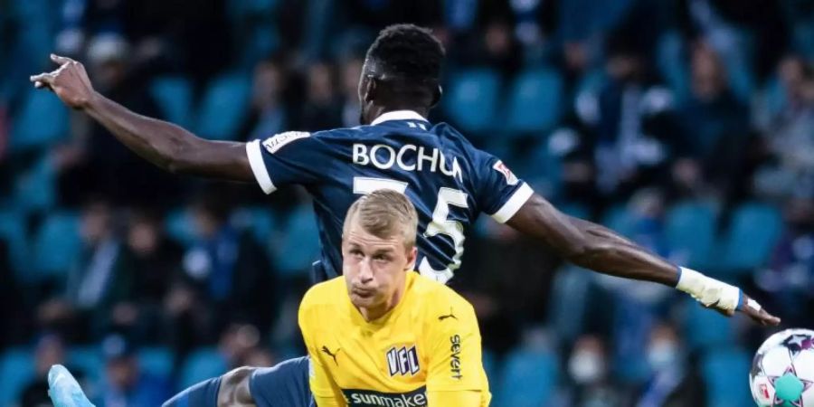 Silvère Ganvoula (hinten) vom VfL Bochum und der Osnabrücker Lukas Gugganig im Zweikampf. Foto: Bernd Thissen/dpa