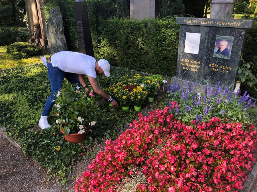 Remo Schmid setzt Blumen auf das Familien Grab von Köbi Kuhn.