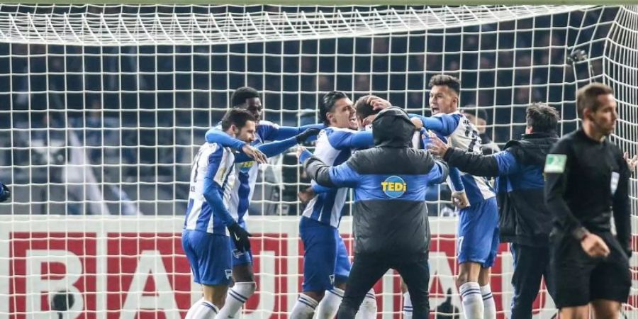 Die Hertha-Profis feiern ihren Sieg im Elfmeterschiessen. Foto: Andreas Gora/dpa