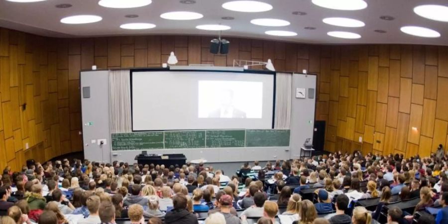 Erstsemester-Studenten sitzen bei einer Begrüssungsveranstaltung im Audimax der Leibniz Universität Hannover. Foto: Julian Stratenschulte/dpa