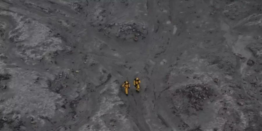 Nach dem Ausbruch: zwei Einsatzkräfte auf White Island. Foto: -/New Zealand Defence Force/dpa