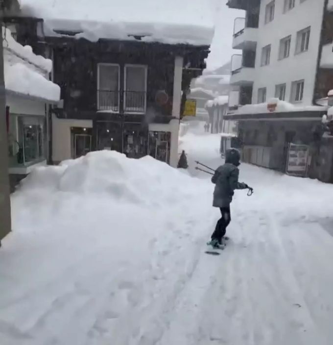 Ein Mann fährt mit seinem Snowboard durch Saas-Fee. Saas-Fee
